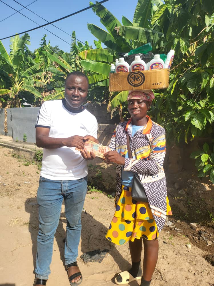 Ibrahim Oppong Kwarteng, CCF Executive Director in picture pose with Cynthia whiles giving her the money